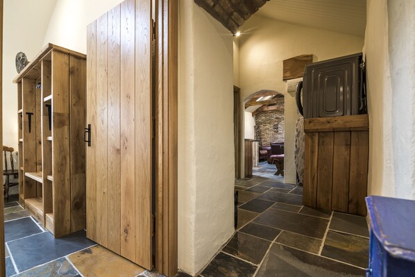A hallway with wooden cabinets and stone flooring. - Lavender - Luxurious Barn Conversion (Haverfordwest)