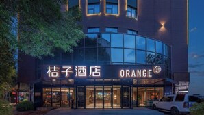 A hotel entrance with signage for 'Orange' and 'Kuson Hotel'. - Orange Hotel (Tianjin Wudadao) (Tianjin)