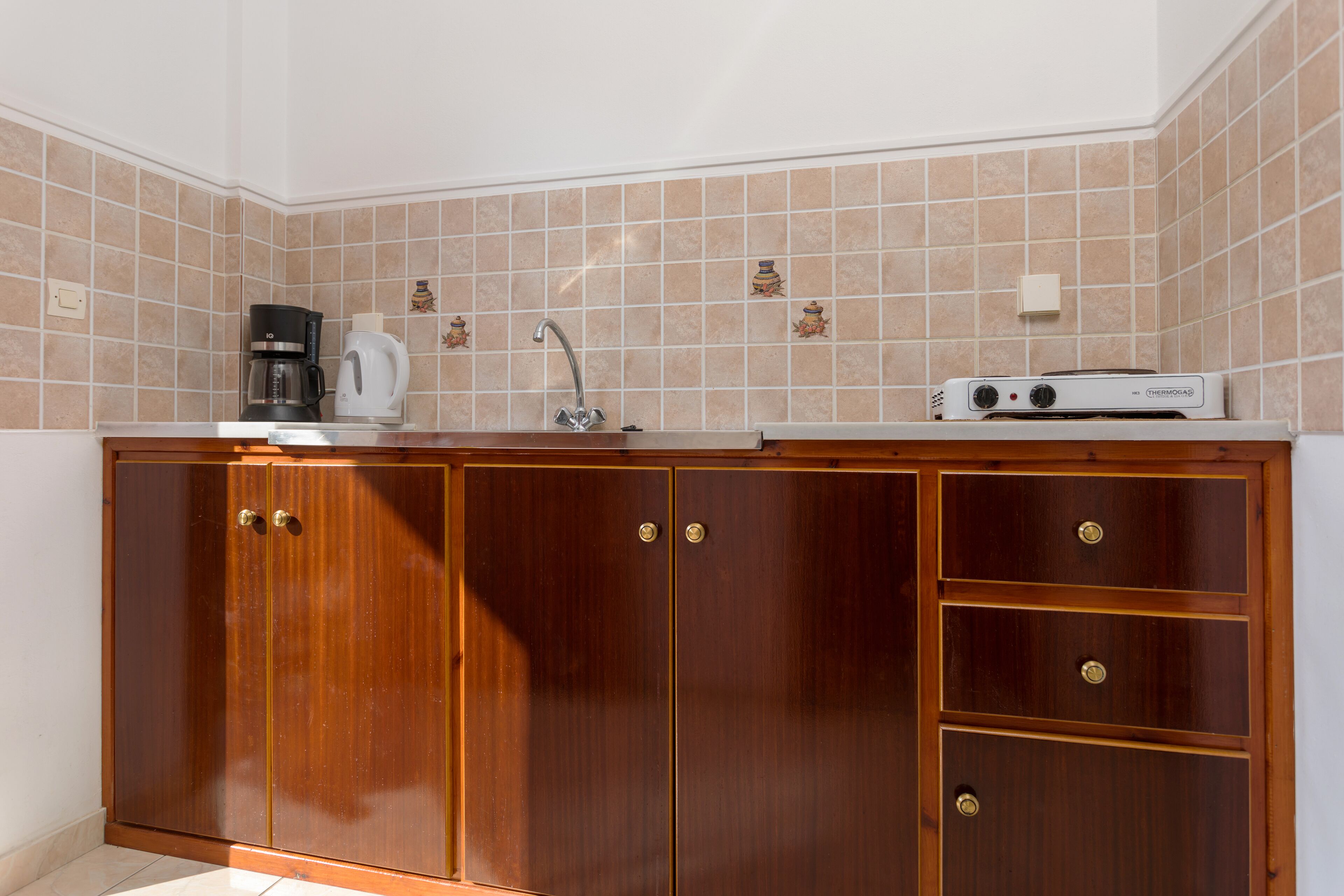A kitchen with wooden cabinets, a coffee maker, and a microwave.