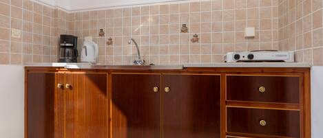 A kitchen with wooden cabinets, a coffee maker, and a microwave.