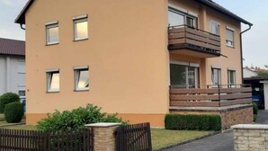A two-story residential building with a flat roof, multiple windows, and a balcony on the upper floor. - Ferienwohnung Anni (Dörfles-Esbach)