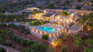 Une villa de luxe dotée d’une piscine, d’une architecture en pierre et de jardins aménagés.