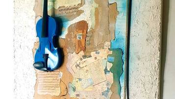 Una obra de arte mural con un violín y un arco sobre una superficie texturizada.
