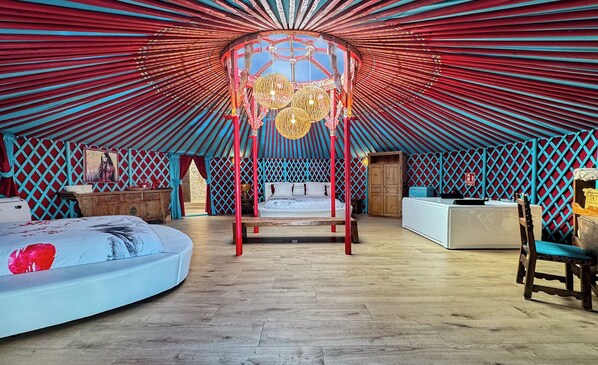 A spacious, well-lit tent with a central bed, a wooden chest, and a small table. - Cortijo Boutique Marbella (Marbella)