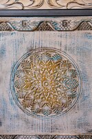 Een gedetailleerd cirkelvormig patroon met ingewikkelde decoraties, mogelijk onderdeel van een versierde wand of paneel.