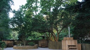 Une terrasse en bois dotée de sièges intégrés et d’une structure de sauna.
