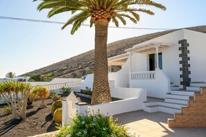 A white building with a staircase, a palm tree, and a desert landscape in the background. - Villa Palma Lanzarote (Tías)