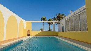 A swimming pool with a clear blue water, surrounded by yellow walls and a white ceiling. - Villa Palma Lanzarote (Tías)