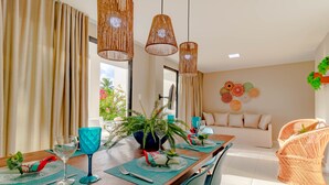 Un comedor con una mesa de madera, individuales azules y una planta en maceta.