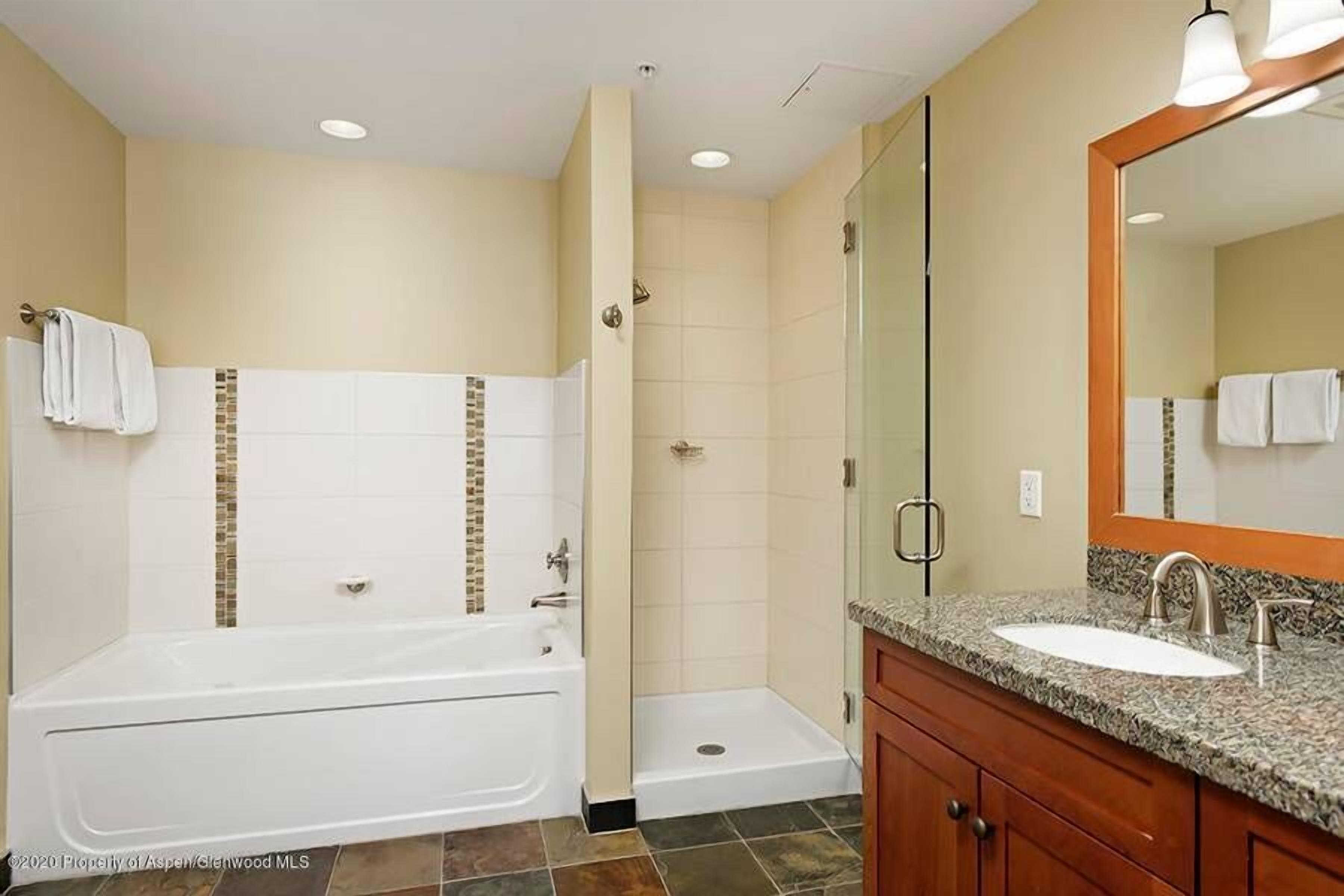 Une salle de bain moderne avec une baignoire, une douche et un meuble-lavabo.