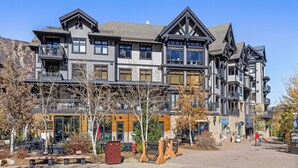 A multi-story hotel with balconies, a stone facade, and a clear sky.