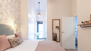 Une chambre à coucher avec un lit, une lampe de chevet et un miroir.