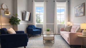 A living room with a blue armchair, a pink sofa, a coffee table, and a plant.