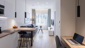 A modern kitchen with a dining area, a laptop on a desk, and a sofa. - Hestia - Ippokratous 35 (Athens)