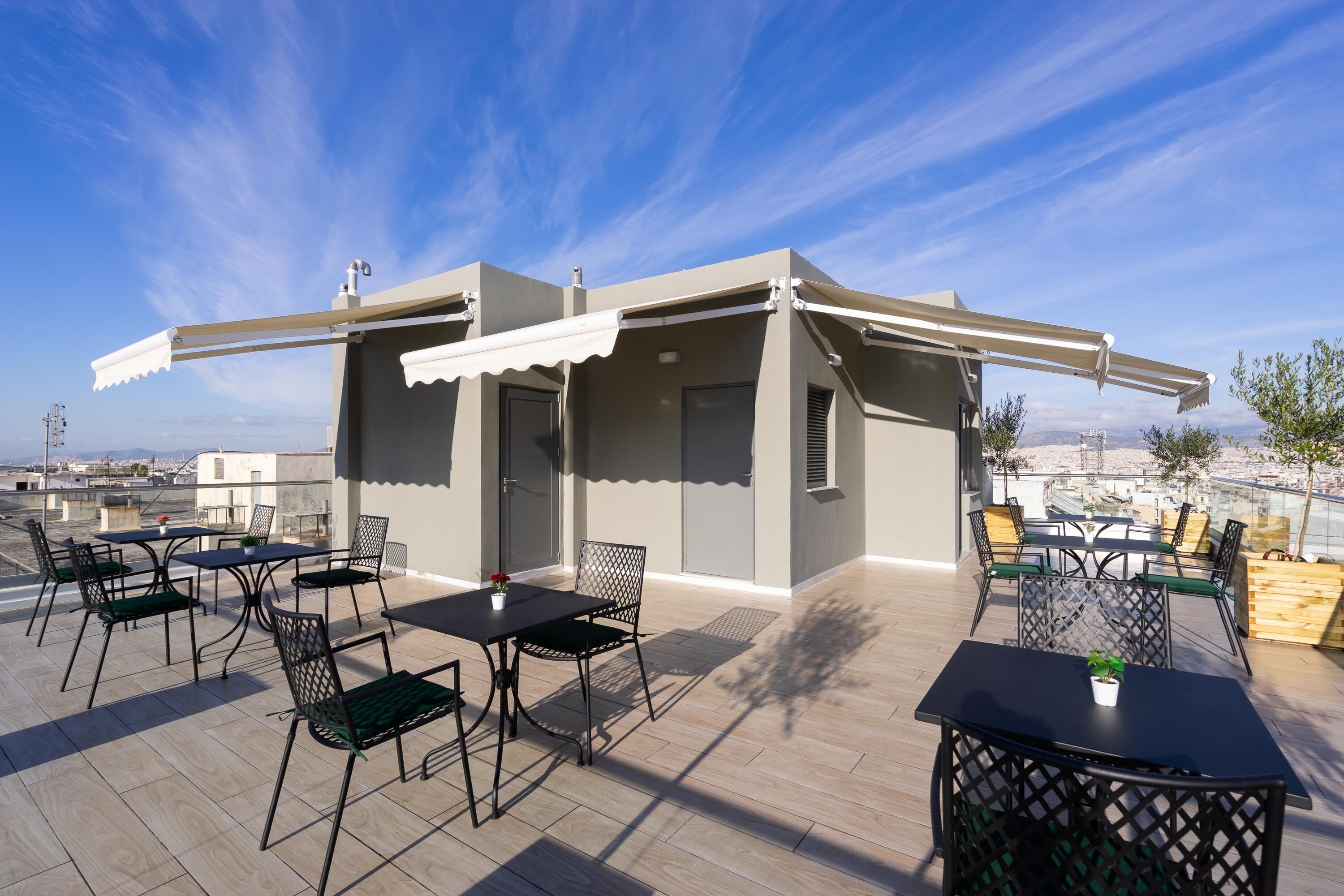 Terraço no telhado com área de estar externa, pérgula e vista para a cidade.