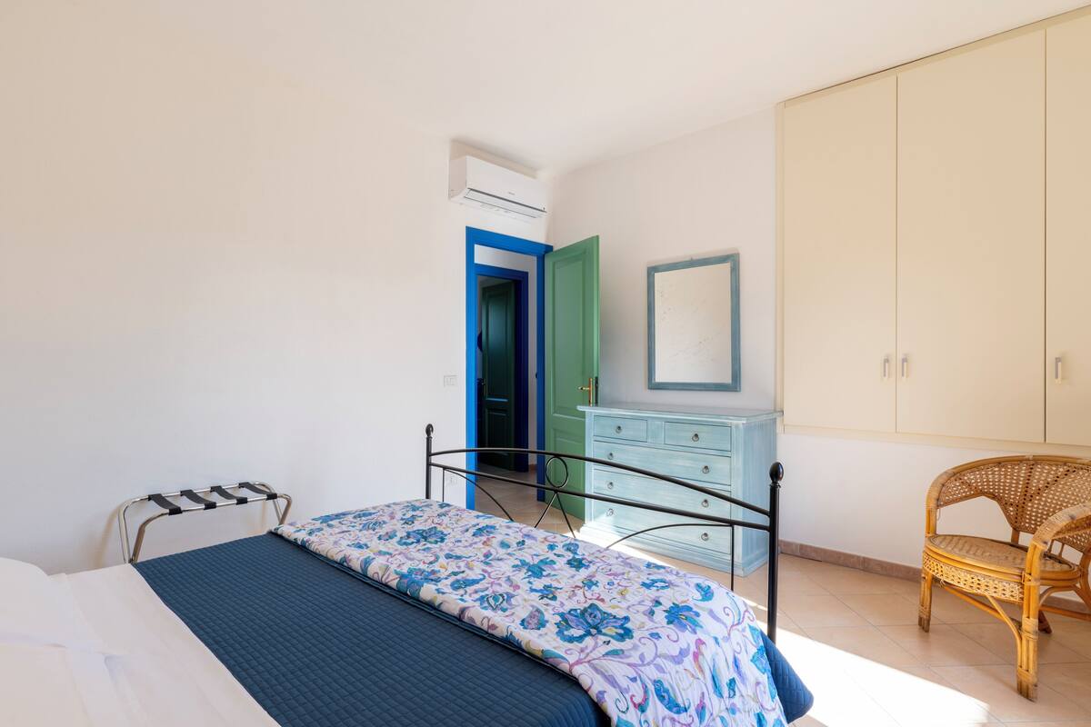 A bedroom with a bed, a dresser, a chair, and a wardrobe.