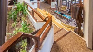 Un interior espacioso con techo de madera, una zona de estar con mesa de billar y vistas al exterior.