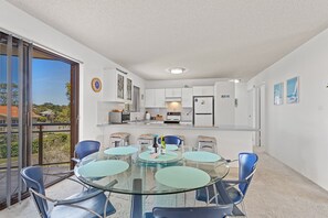 A modern kitchen with white cabinets, a built-in oven, and a refrigerator.