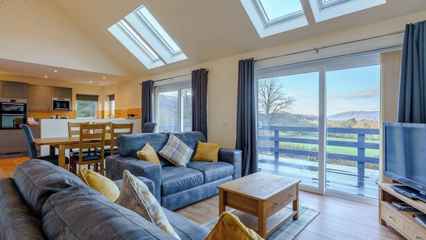 A modern living room with a sofa, a coffee table, and a TV stand. - 3 bedroom accommodation in Duror (Duror)