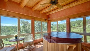 A wooden interior with large windows, a ceiling fan, and a round hot tub. - Luxury Million Dollar Mountain Views: Golf Course Community across Ski Area!  (Angel Fire)