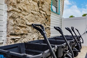 Wheelbarrows line the stone wall, awaiting use in the garden.