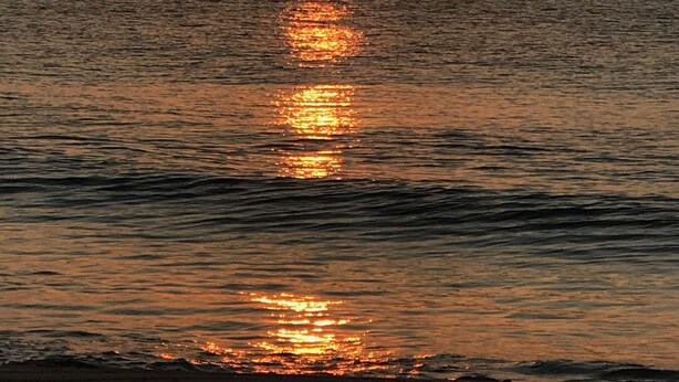 A sunset over the ocean with a calm sea reflecting the sun's light. - 3BD-2BA 2nd flr Dreamy Rehoboth Beach Getaway (Rehoboth Beach)