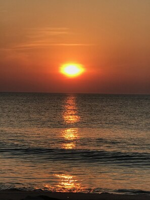 A sunset over the ocean with a calm sea reflecting the sun's light. - 3BD-2BA 2nd flr Dreamy Rehoboth Beach Getaway (Rehoboth Beach)