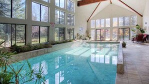 Ein großes Hallenbad mit hoher Decke und großen Fenstern.