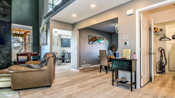 A spacious living area with a fireplace, a dining table, and a kitchen in the background. - Spacious Modern Gorgeous Mountain Views Fort Carson Fire Pit!  (Colorado Springs)