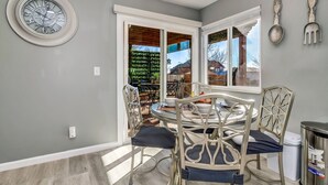 A dining area with a round table, four chairs, and a window with blinds. - Spacious Modern Gorgeous Mountain Views Fort Carson Fire Pit!  (Colorado Springs)