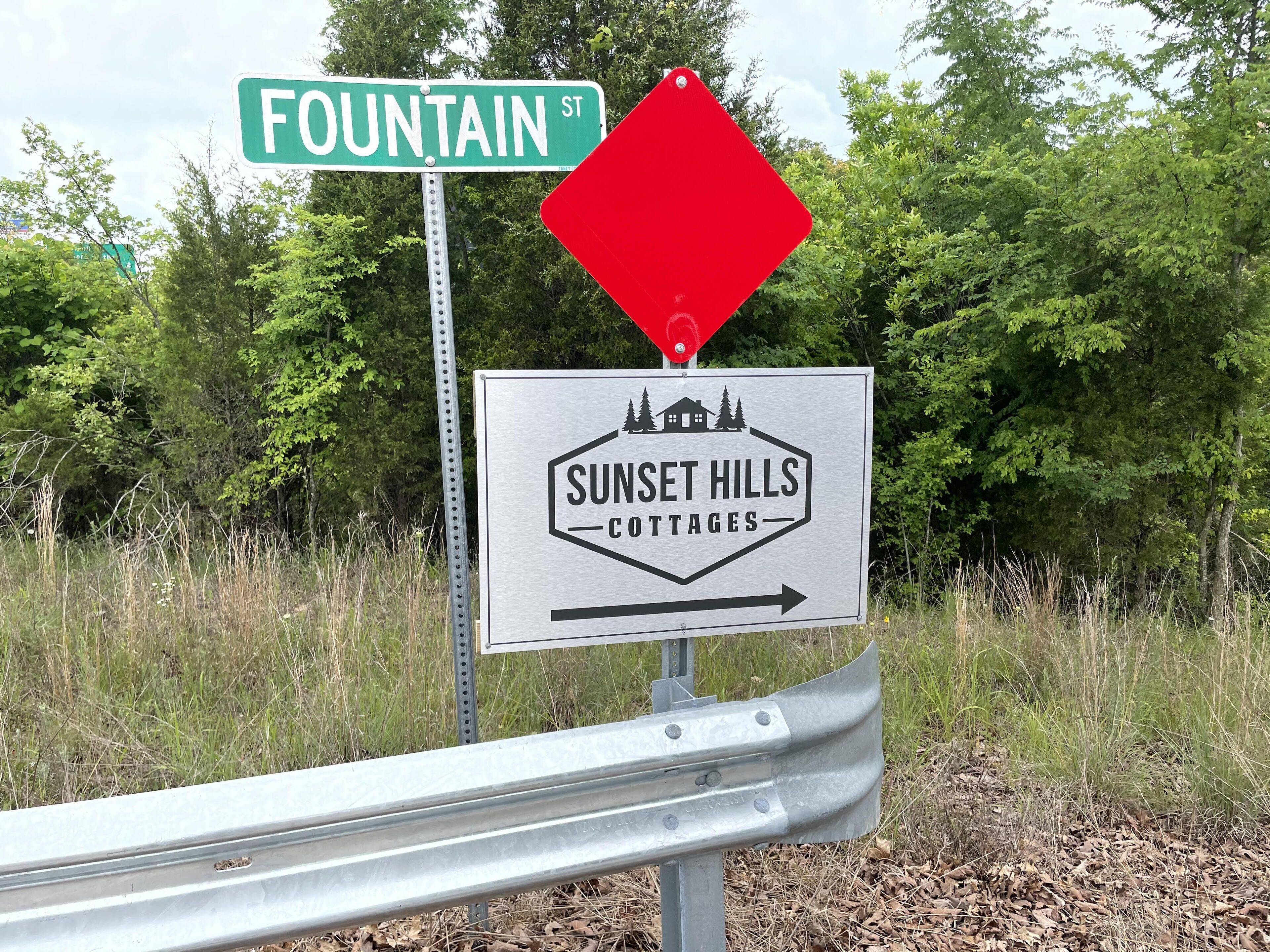 A street sign for Fountain St. and a directional sign for Sunset Hills Cottages.