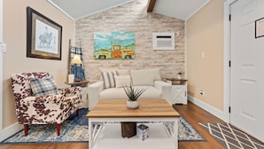 A cozy living room with a wooden coffee table, a sofa, and a chair with a plaid pattern.