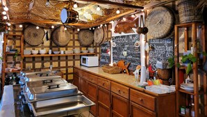 Ein Restaurantinneres mit einem gemusterten Decken, Buffetstischen und einer Kreidetafel-Speisekarte.