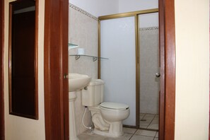 A bathroom with a toilet, sink, and glass shelf. - Bungalows Yessy Tetos (Rincón de Guayabitos)