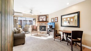 A living room with a fireplace, a television, and a dining area. - Park City Ski In and Out Studio at Resort Center (Park City)
