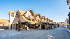 A row of modern buildings with balconies, a coffee shop, and a clear sky. - Park City Ski In and Out Studio at Resort Center (Park City)