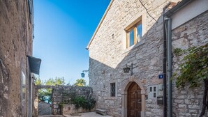 A stone building with a wooden door, a small window, and a number '8' sign. - Stunning stone house nestled in the heart of the historic old town of Vrsar. (Vrsar)