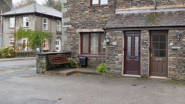 A stone building with a brown door and windows, labeled 'Printers Cottage.' - 2 bedroom accommodation in Ambleside (Ambleside)