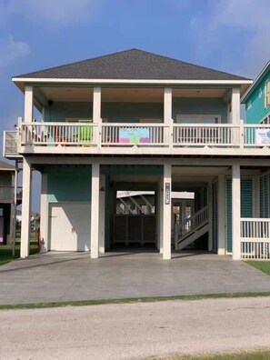 A two-story building with a covered entrance and a balcony on the upper floor.