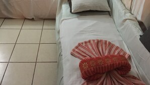 Une chambre avec deux lits, chacun étant équipé d’un oreiller et d’une couverture. Un tableau est accroché au mur, au-dessus des lits.