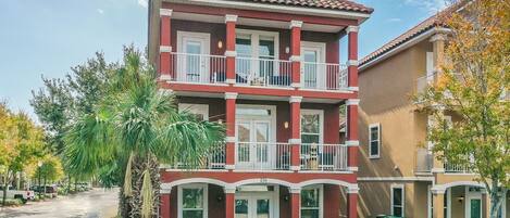 A two-story residential building with a red and beige exterior, multiple balconies, and a number '256' displayed.