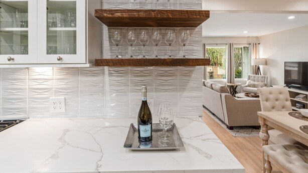 A modern kitchen with a marble countertop, wine glasses, and a bottle of wine on a tray. - Modern Beach House Oasis w/ Private Patio (san diego)