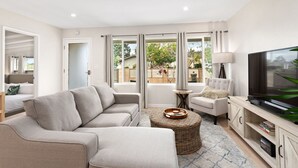A modern living room with a sofa, armchair, and TV stand. - Modern Beach House Oasis w/ Private Patio (san diego)
