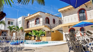 A hotel with a pool, outdoor seating, and a staircase leading to an upper level. - Bungalows Maria Teresa (Rincón de Guayabitos)