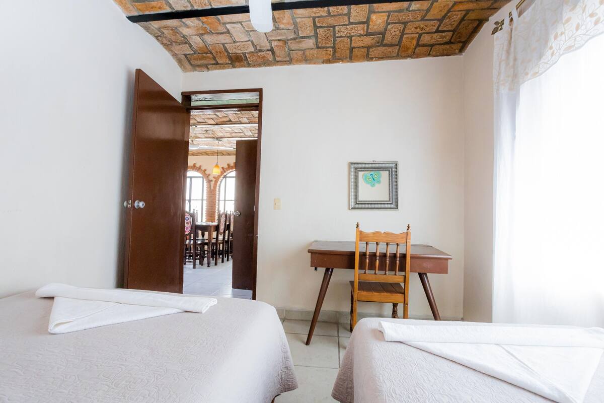 Una habitación de hotel con dos camas, un escritorio y una silla.