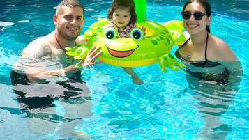 Alberca al aire libre, sombrillas en la alberca y camastros