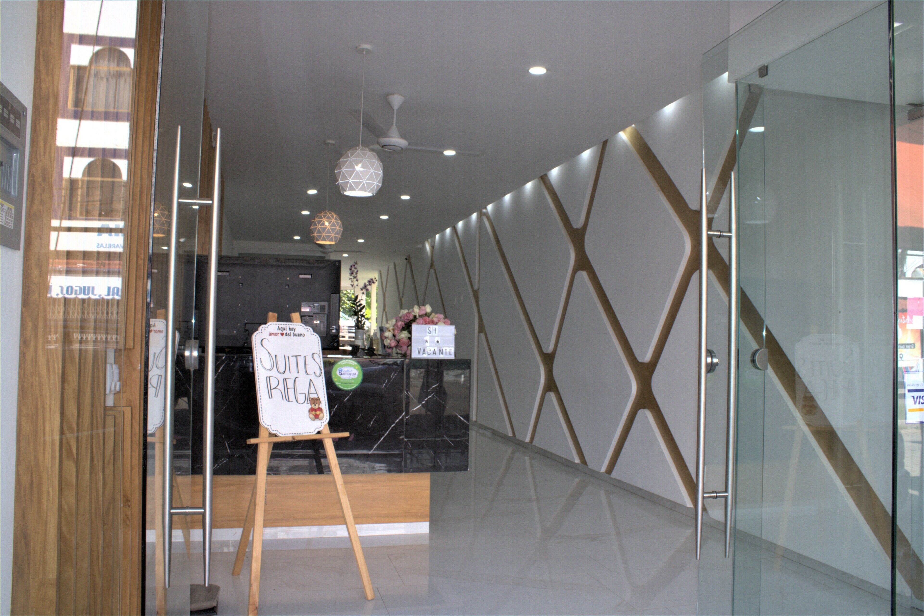 Un interior moderno con un mostrador de recepción, una pared divisoria de vidrio y un suelo de madera.