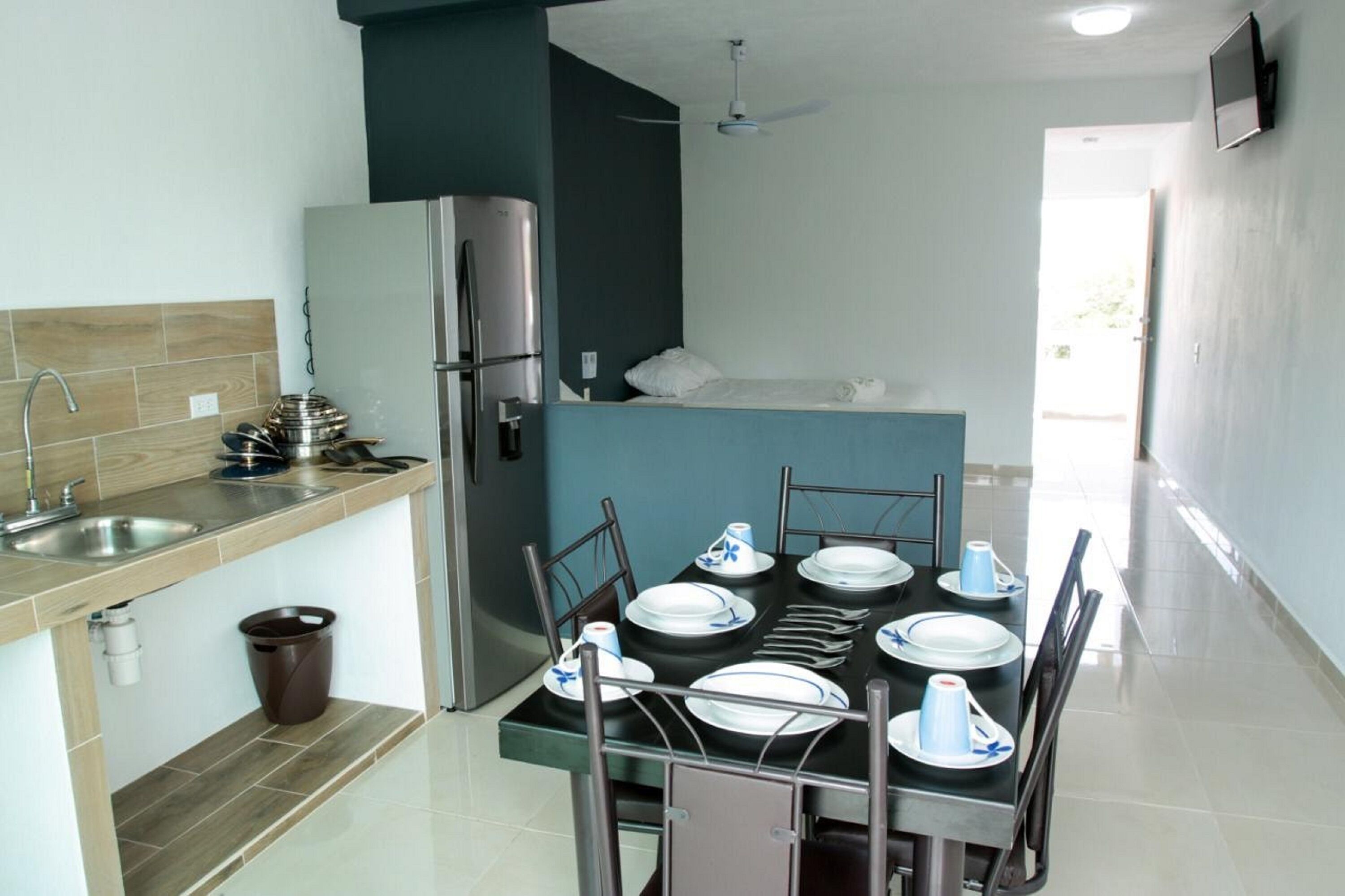 Een moderne keuken met een koelkast, gootsteen en een eethoek, klaar voor een maaltijd.