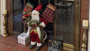A fireplace with a decorative mantel, a Santa Claus figure, and Christmas stockings.