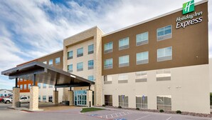 A Holiday Inn Express building with a covered entrance, parking lot, and handicap-accessible parking spaces. - Holiday Inn Express Kermit By IHG (Kermit)
